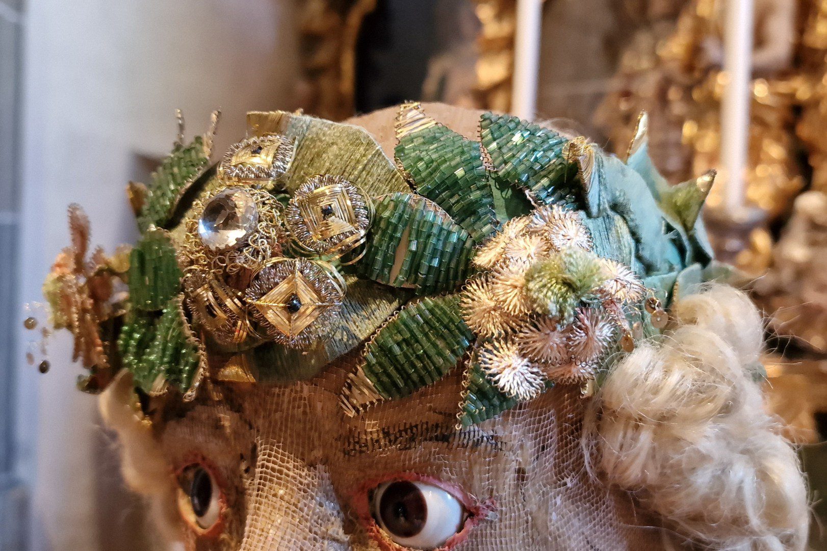 Der Kopf des Katakombenheiligen ist mit einem Lorbeerkranz und Perücke geschmückt. Tomedi Textilrestaurierung